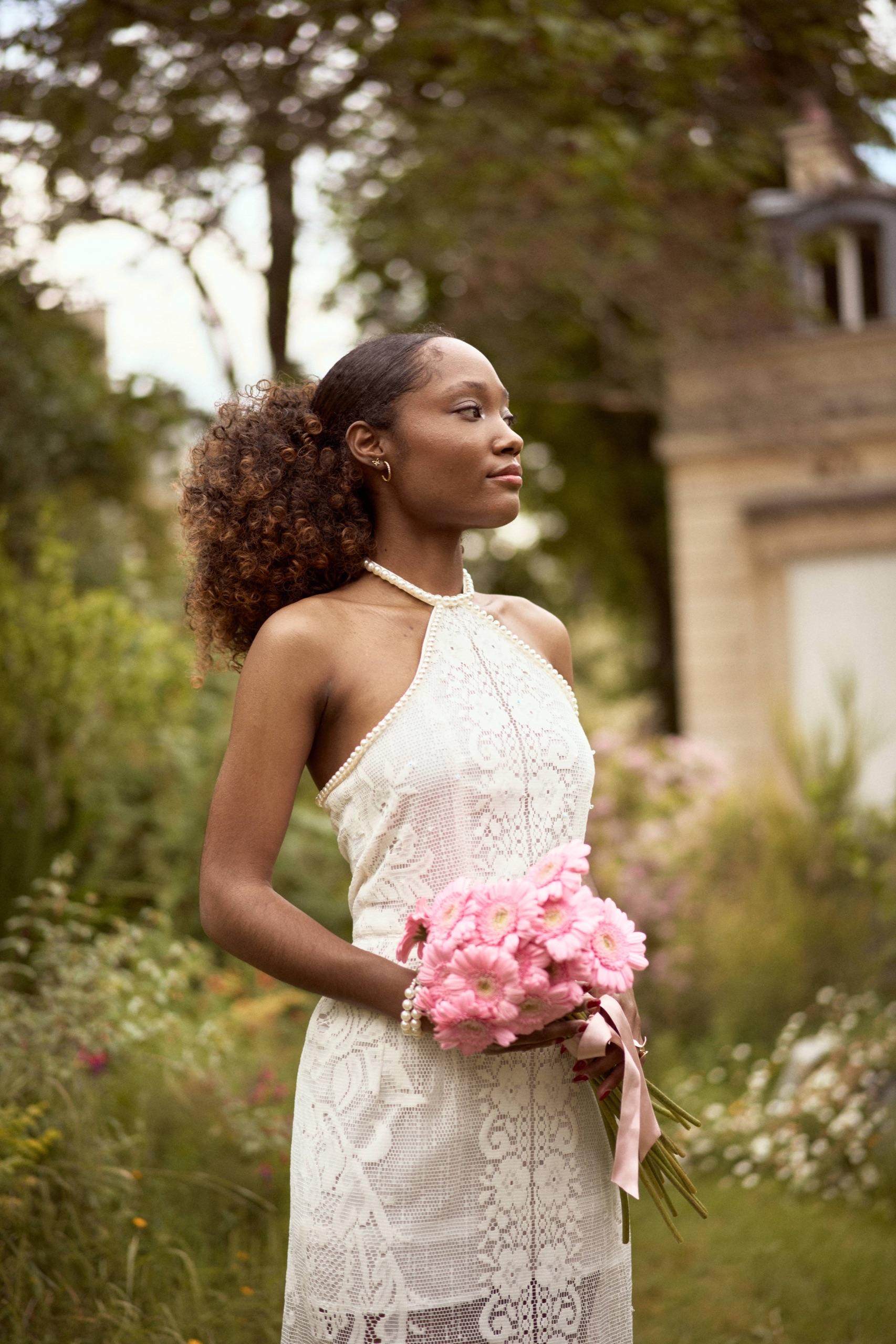 Sarah portant sa robe en dentelle et son collier de perles